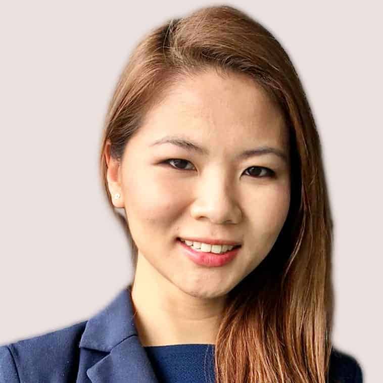 Professional woman with long brown hair smiling in a business suit.